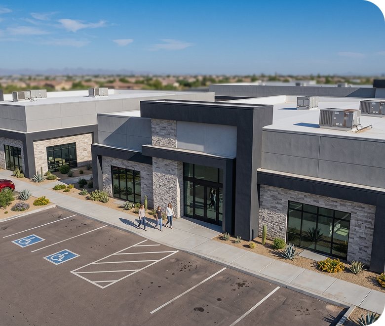 Elevated view of a single-storey commercial building with a stone and stucco facade, beside a marked parking area with accessible spaces